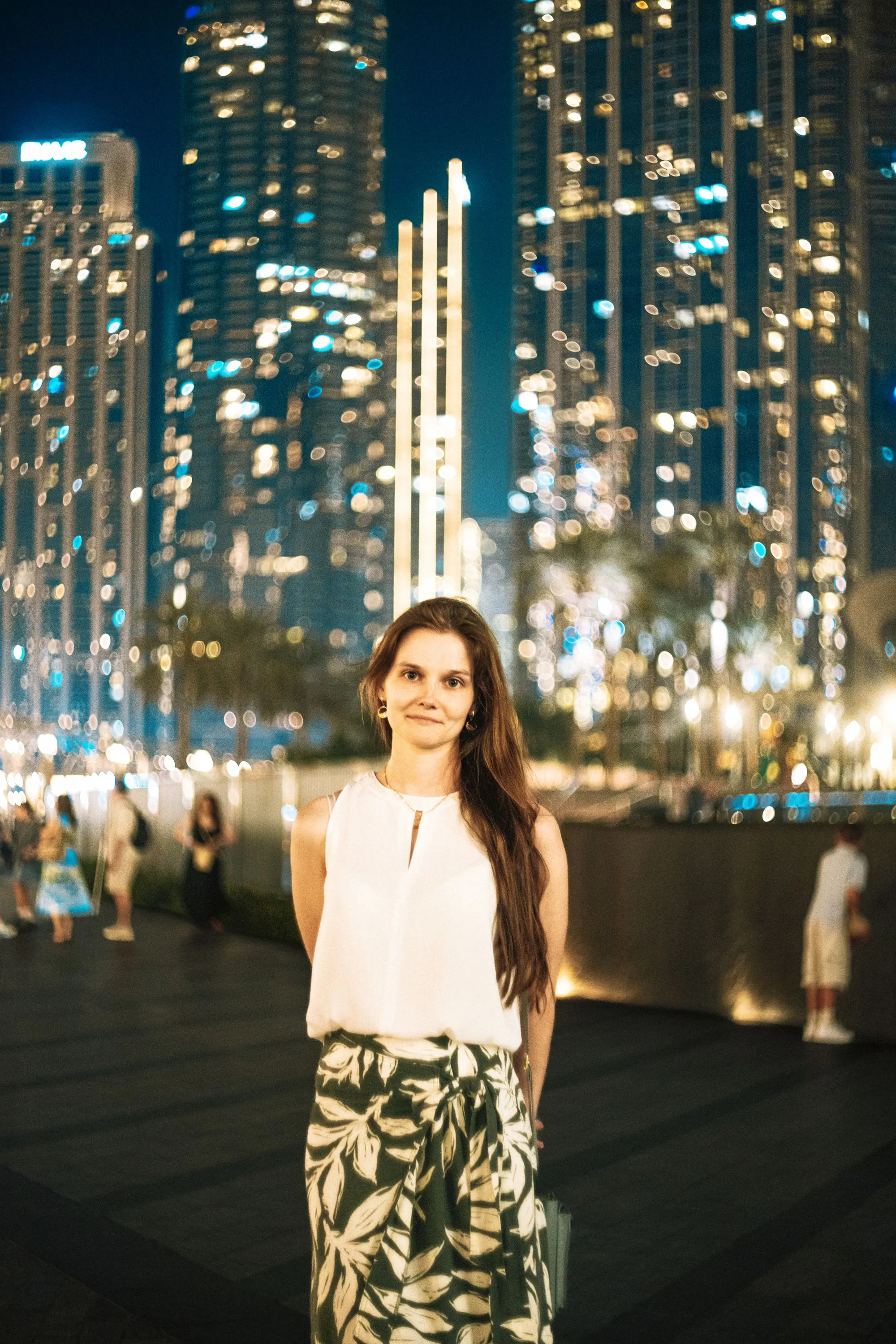 Woman in Dubai at night with the skyline behind